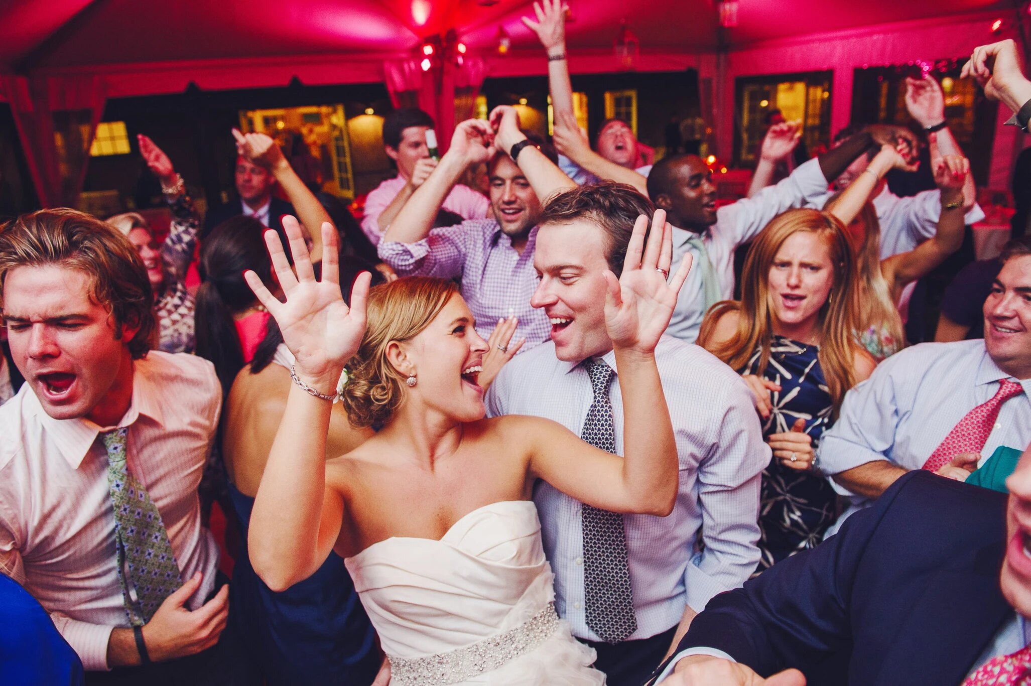 Packed wedding dance floor with event lighting